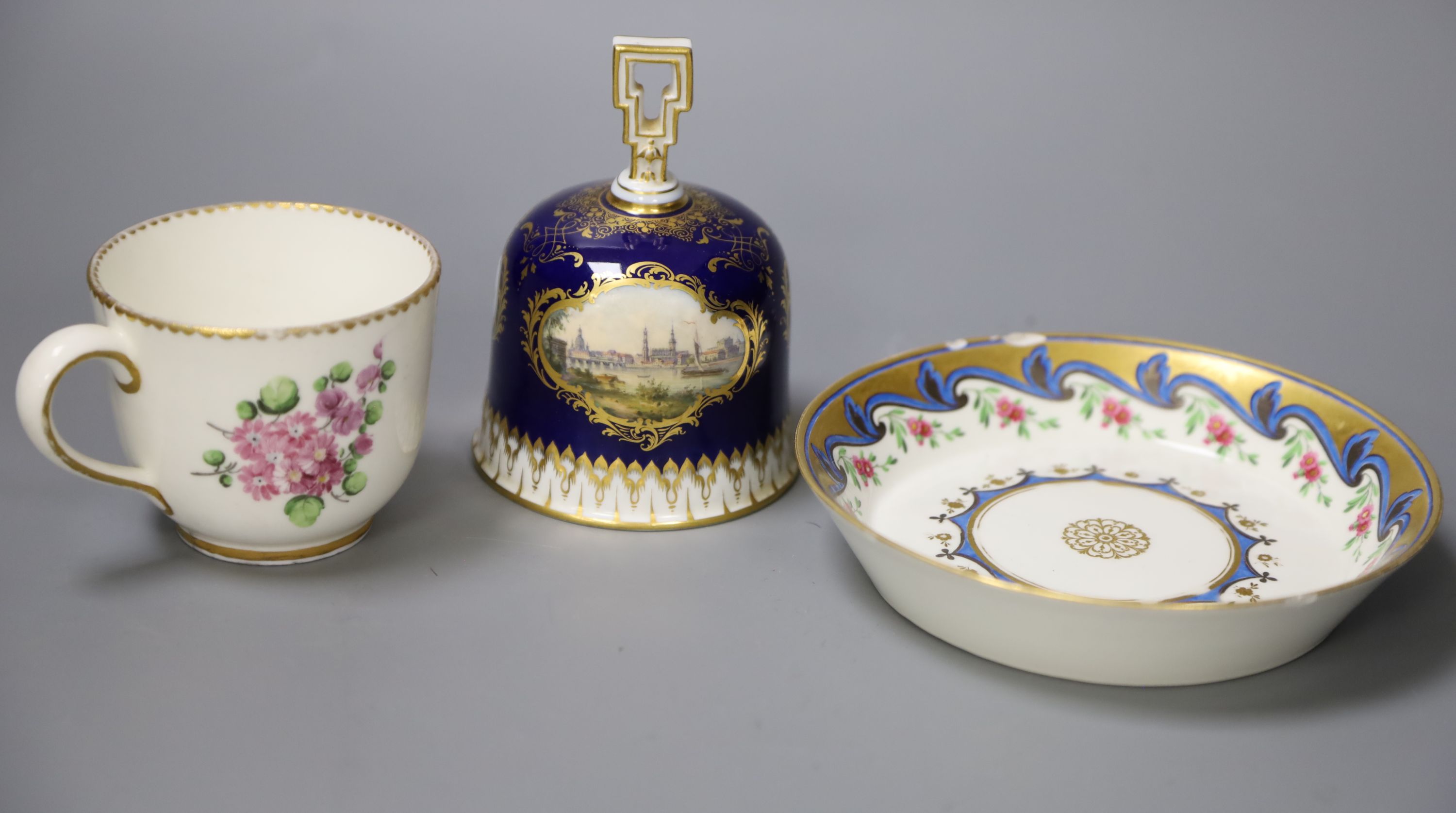 A Meissen hand-painted table bell, a Vienna saucer, diameter 13.5cm, and a Sevres cup